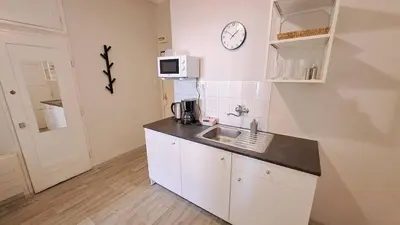 a kitchen with a sink and a clock on the wall at Flat in Zizkov -402- in Prague