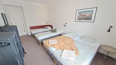 a room with three beds and a tv at Flat in Zizkov -402- in Prague