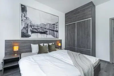 a bedroom with a large white bed and a painting at Rentero Wenceslas square Apartment, Prague in Prague