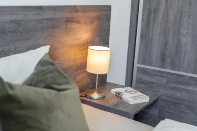 a lamp on a night stand next to a bed at Rentero Wenceslas square Apartment, Prague in Prague