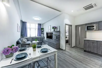 a kitchen and living room with a table and a couch at Rentero Wenceslas square Apartment, Prague in Prague