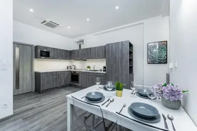 a kitchen with a white table and some glasses at Rentero Wenceslas square Apartment, Prague in Prague