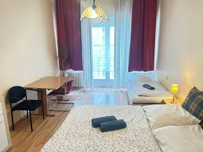 a room with two beds and a table and a desk at Rooms in the Center of Old Town in Prague