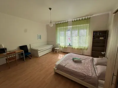 a bedroom with a bed and a desk and a window at Rooms in the Center of Old Town in Prague