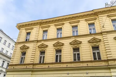 a yellow building with windows on the side of it at Apartments Kamenicka 23 in Prague