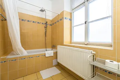 a bathroom with a tub and a shower and a sink at Apartments Kamenicka 23 in Prague