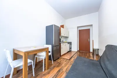 a kitchen and dining room with a table and a refrigerator at Apartments Kamenicka 23 in Prague