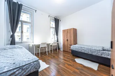 a bedroom with two beds and a table with chairs at Apartments Kamenicka 23 in Prague