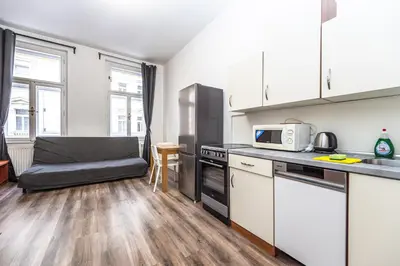 a kitchen with a microwave and a couch in a room at Apartments Kamenicka 23 in Prague