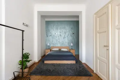 a bedroom with a bed and a blue wall at Spacious apartment with balcony at Wenceslas Sq in Prague