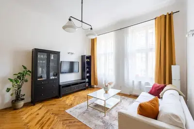 a living room with a white couch and a tv at Spacious apartment with balcony at Wenceslas Sq in Prague