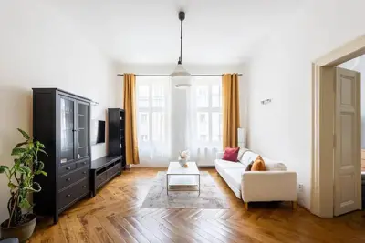 a living room with a white couch and a tv at Spacious apartment with balcony at Wenceslas Sq in Prague