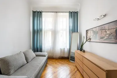 a living room with a couch and a dresser at Spacious apartment with balcony at Wenceslas Sq in Prague
