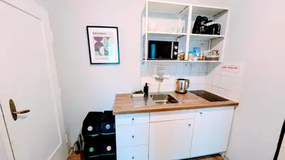 a small kitchen with a sink and white cabinets at Flat in Zizkov -401- in Prague