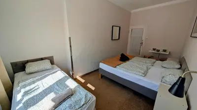 a bedroom with two beds and a table in it at Flat in Zizkov -401- in Prague