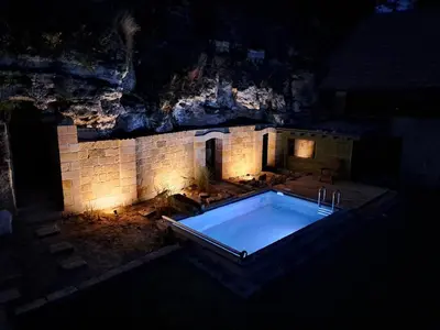 a swimming pool in a cave with a stone wall at Chalupa Zátyní - celý objekt in Dubá