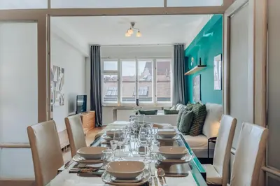 a dining room with a table and a couch at Downtown 2BD riverside apartment near dancing house in Prague