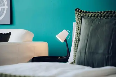 a bedroom with a bed with a lamp and a green wall at Downtown 2BD riverside apartment near dancing house in Prague