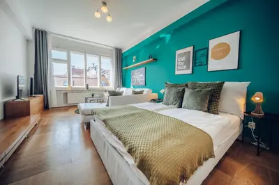 a bedroom with a large bed and a blue wall at Downtown 2BD riverside apartment near dancing house in Prague