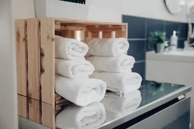 a stack of towels on a counter in a bathroom at Downtown 2BD riverside apartment near dancing house in Prague