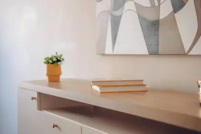 a shelf with books and a potted plant on it at Downtown 2BD riverside apartment near dancing house in Prague