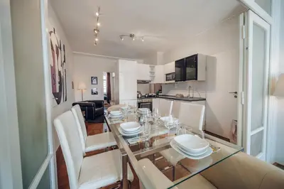 a dining room and kitchen with a glass table and chairs at Downtown 2BD riverside apartment near dancing house in Prague
