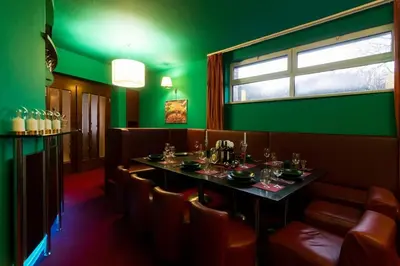 a green dining room with a table and chairs at Private Hostel Casino Royal in Prague