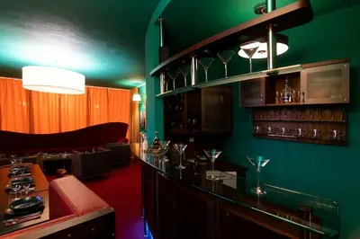 a green room with a bar with wine glasses at Private Hostel Casino Royal in Prague