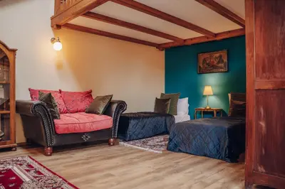 a living room with a red chair and a bed at Magnificent historical penthouse in the heart of Prague in Prague