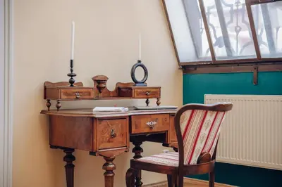 an old wooden desk with a chair and a window at Magnificent historical penthouse in the heart of Prague in Prague