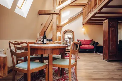 a living room with a wooden table and chairs at Magnificent historical penthouse in the heart of Prague in Prague