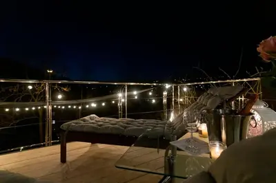 a balcony with a bed and a table and lights at Vila U Blaženky in Prague