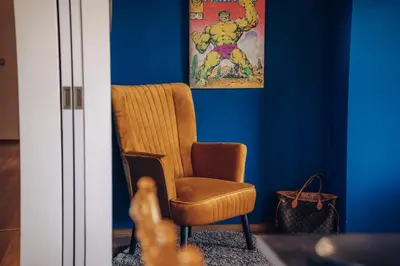 a orange chair in a room with blue walls at Marvel 2BD Apartment in modern villa with cozy terrace in Prague