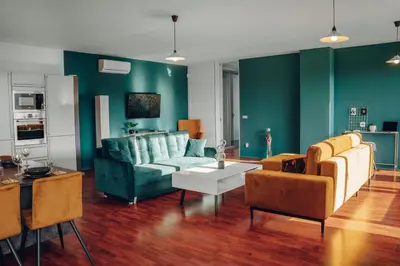 a living room with green walls and a blue couch at Design 3BD apartment cooking area in architect villa in Prague