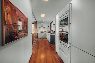 a kitchen with white walls and wood floors and a kitchen with appliances at Design Architect Villa with 2 Apartments in Prague