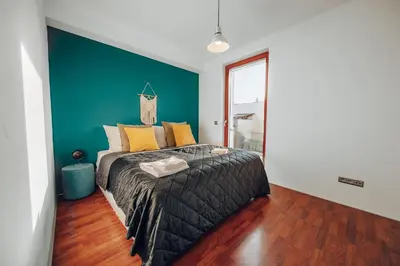 a bedroom with a bed with a blue accent wall at Design Architect Villa with 2 Apartments in Prague