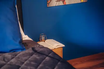 a bedroom with a blue wall and a table with a bed at Design Architect Villa with 2 Apartments in Prague