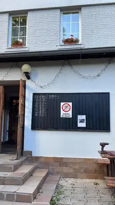 a building with a black gate and a sign on it at Penzion Troníček in Kamenný Přívoz
