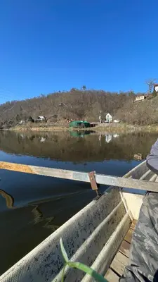 a person sitting on a boat on a body of water at Penzion Troníček in Kamenný Přívoz