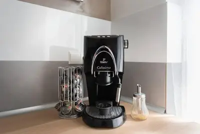 a black coffee maker on a counter with other appliances at 2 bedrooms apt near Wenceslas sq in Prague