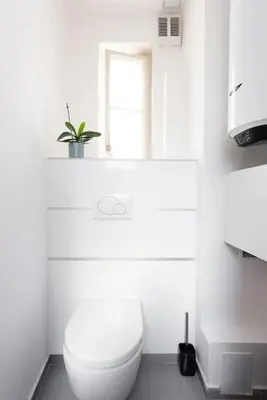 a white bathroom with a toilet and a window at 2 bedrooms apt near Wenceslas sq in Prague