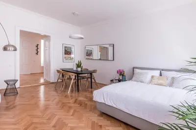 a white bedroom with a bed and a table at New design APT - central location Wenceslas Square in Prague
