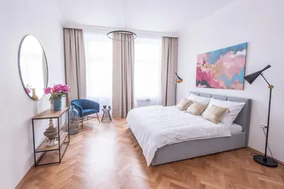 a bedroom with a bed and a table and a mirror at New design APT - central location Wenceslas Square in Prague