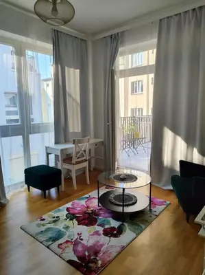 a living room with a coffee table on a rug at Studio with balcony in Vinohrady in Prague