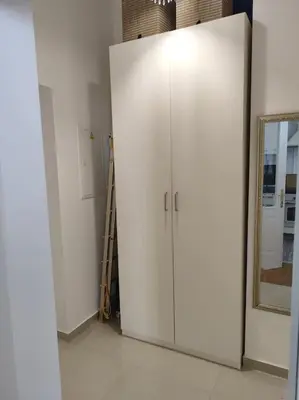 a white cabinet in a room with a mirror at Studio with balcony in Vinohrady in Prague