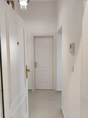 a hallway with a white door and a white floor at Studio with balcony in Vinohrady in Prague