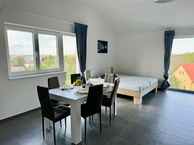 a dining room with a table and chairs and a bed at Byt apartman 2rooms 76m2 all new in Prague