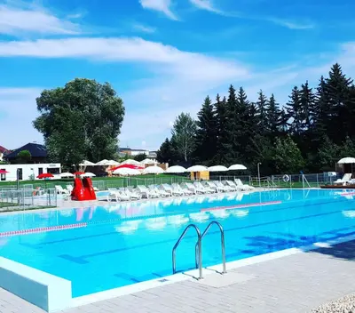 a large swimming pool with chairs and umbrellas at Byt apartman 2rooms 76m2 all new in Prague