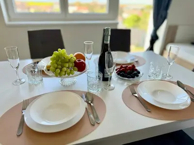 a table with plates and bowls of fruit and a bottle of wine at Byt apartman 2rooms 76m2 all new in Prague