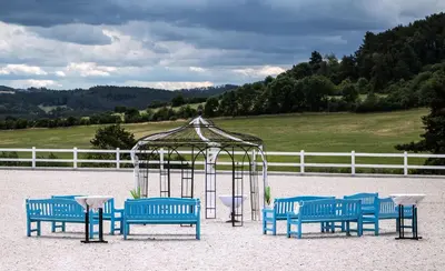 a group of blue benches and a gazebo at Pension Jezerná in Zduchovice